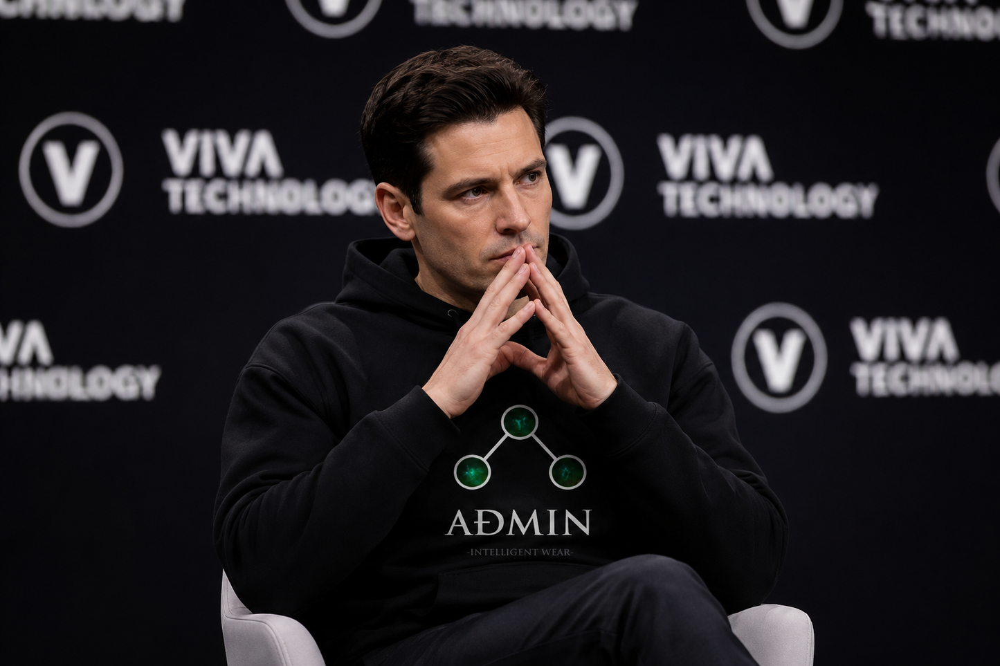 A man wearing a black hoodie with a green and white ADMIN logo sits in a white chair against a black VIVA TECHNOLOGY backdrop.